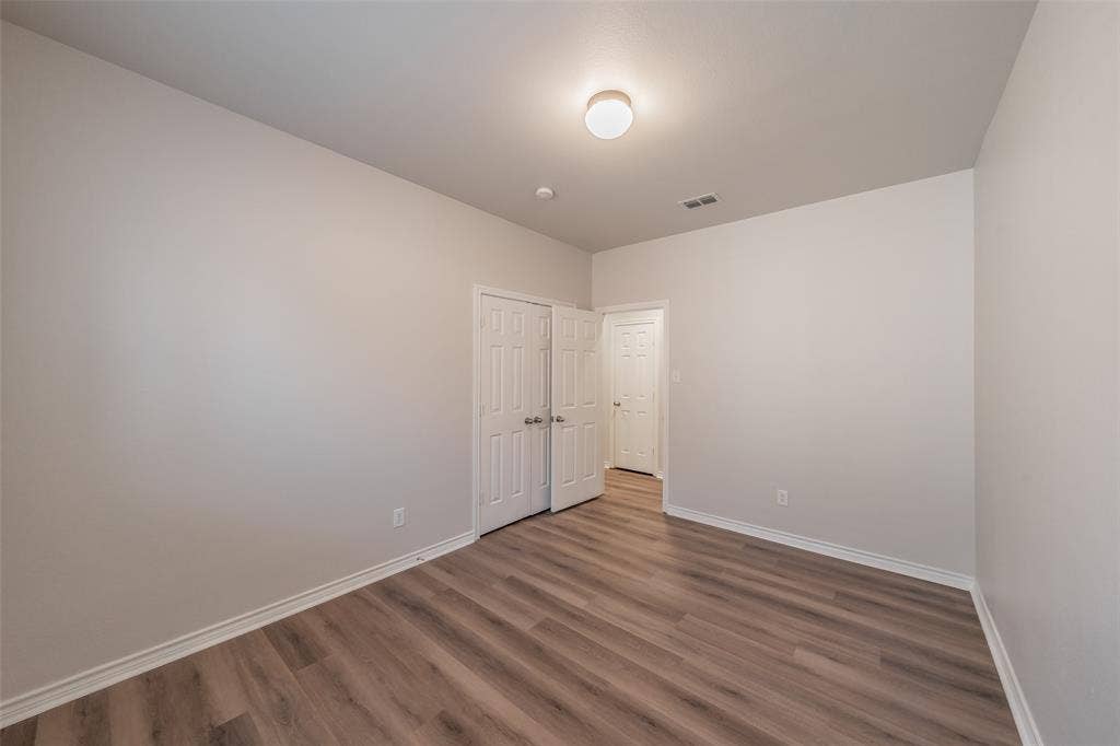 2205 Clairborne Drive, Fort Worth, TX 76177 Wood-finish flooring, white walls, flush mount ceiling light, and white paneled doors