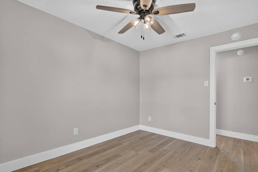 Wood-finish flooring with white baseboards and light gray walls