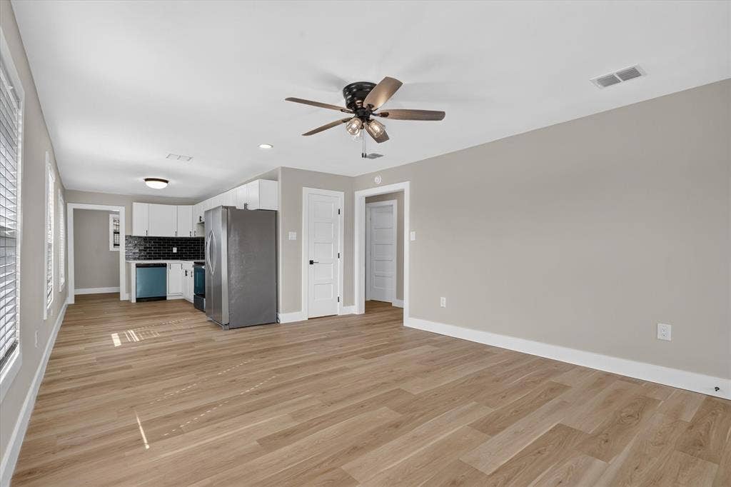Wood-finish flooring, recessed lighting, ceiling fan, white cabinetry, and a black subway tile backsplash