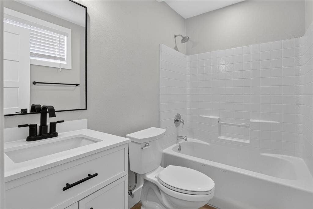 White vanity with black hardware, rectangular undermount sink, black matte faucet, and a rectangular mirror