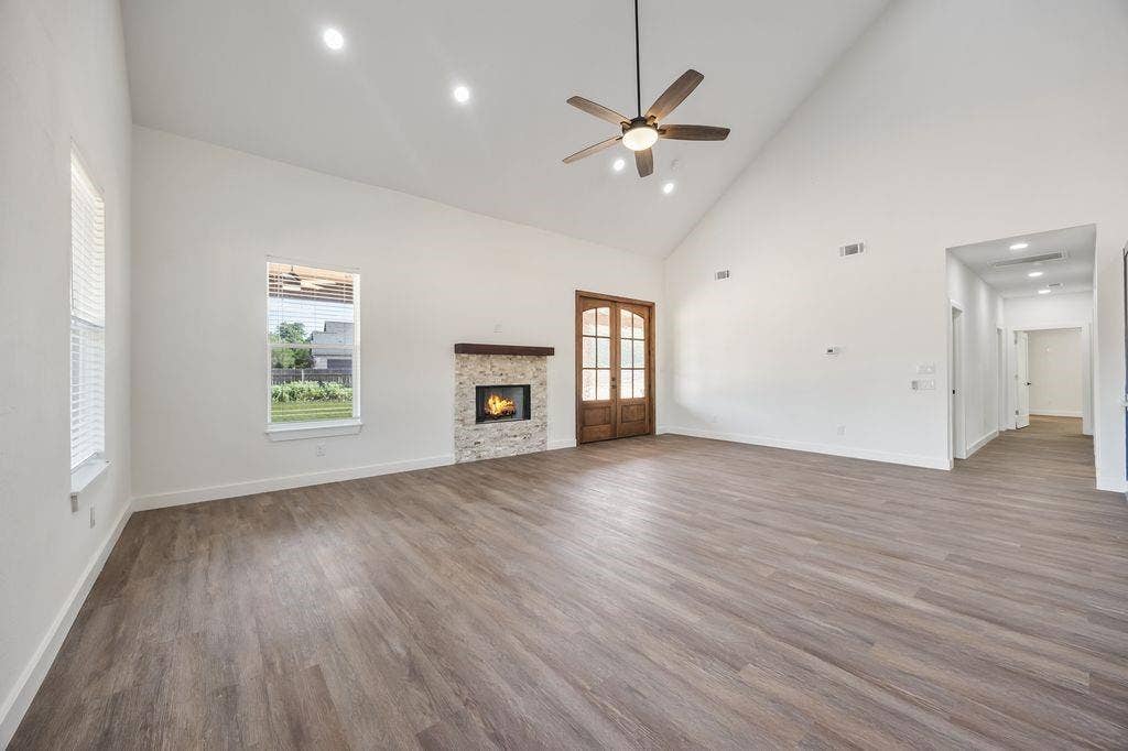 Large living room with fireplace and double doors opening out to the covered patio