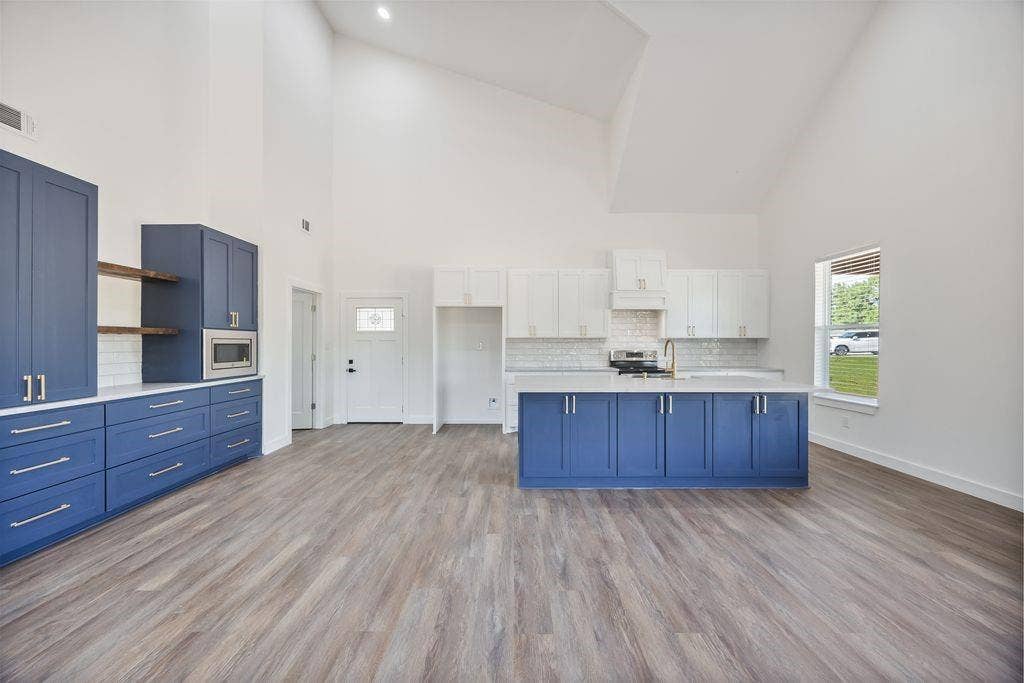 Beautiful blue custom cabinets with gold fixtures, farm house sink and more