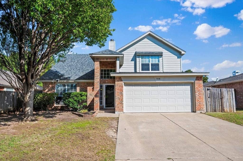 5016 Mill Creek Trail, Fort Worth, TX 76179 Brick and siding exterior with a two-car garage, established front yard tree, and covered entry