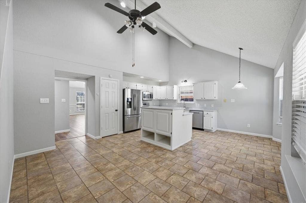 5016 Mill Creek Trail, Fort Worth, TX 76179 Vaulted ceiling, ceiling fan, white cabinetry, stainless steel appliances, and tile flooring