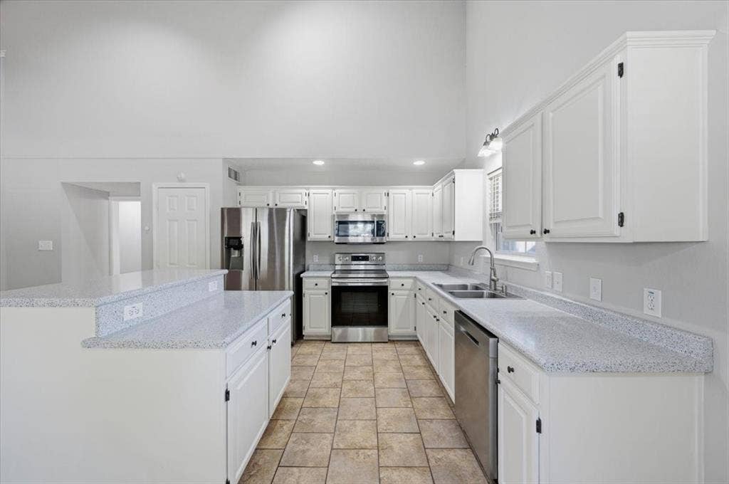 5016 Mill Creek Trail, Fort Worth, TX 76179 Kitchen featuring white cabinetry, light-toned countertops, stainless steel appliances, and tile flooring