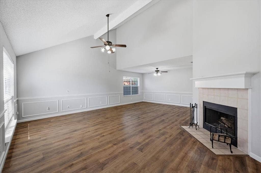 5016 Mill Creek Trail, Fort Worth, TX 76179 Vaulted ceiling, wood-finish flooring, fireplace with tiled surround, ceiling fans, and decorative wainscoting