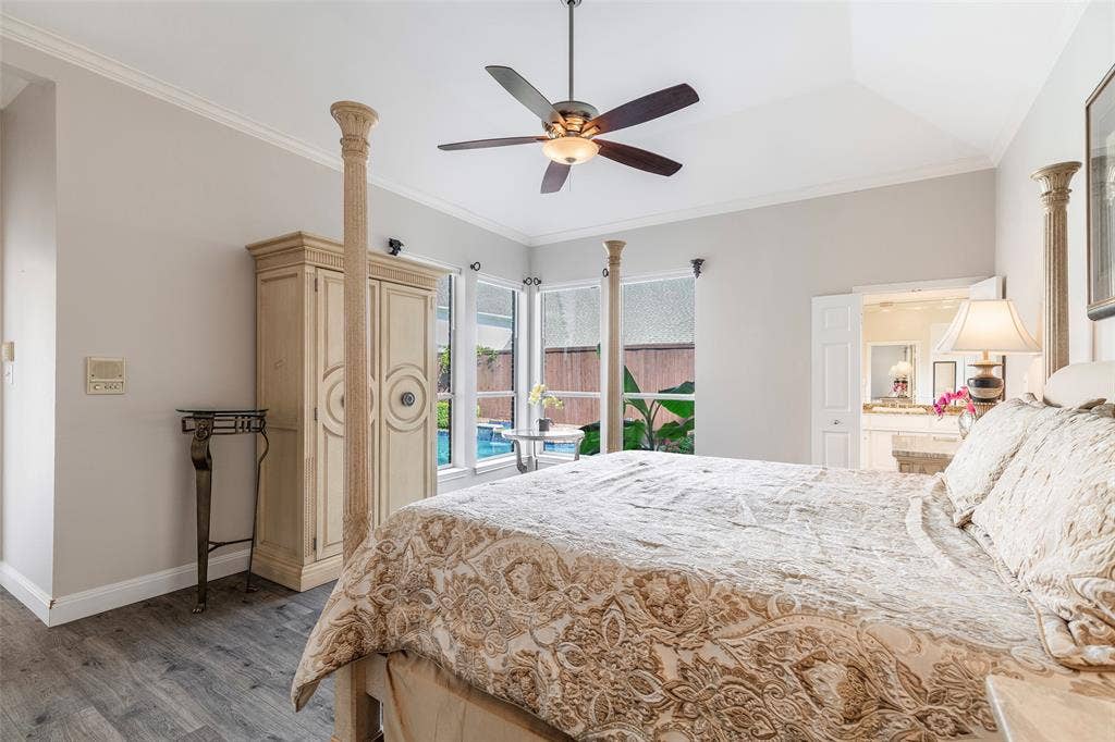 Wake up to views of the backyard pool through a wall of windows that fills the primary bedroom with natural light.