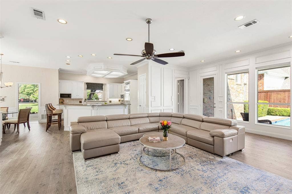The open-concept layout seamlessly connects the spacious, light-filled family room to the adjacent dining area and kitchen, ensuring you never miss a moment of the conversation while entertaining.