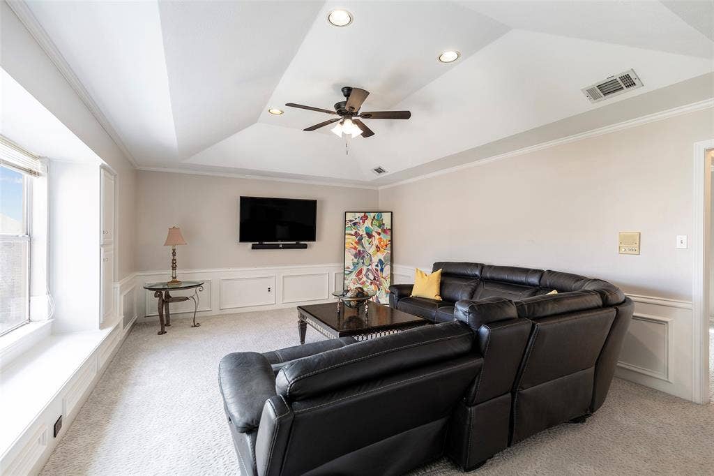 A wide window seat, built-in storage and a raised ceiling add character to this flexible second-floor living space.
