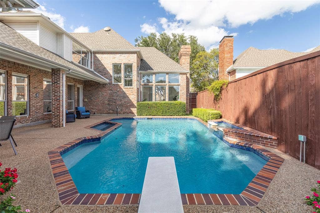 An entertainer's dream layout showcases the deep-water pool equipped with a diving board, surrounded by a robust, all-brick exterior structure.