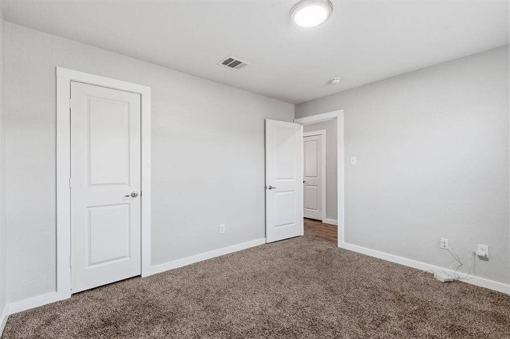 2333 Bellewood Court, Crandall, TX 75114 Neutral wall color with a contrasting white trim, carpeted flooring, and a flush-mount ceiling light