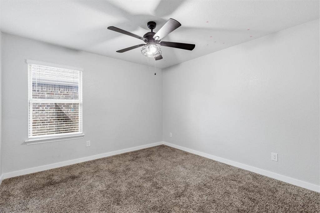2333 Bellewood Court, Crandall, TX 75114 Carpeted interior with light gray walls, a window with blinds, and a ceiling fan with integrated lighting
