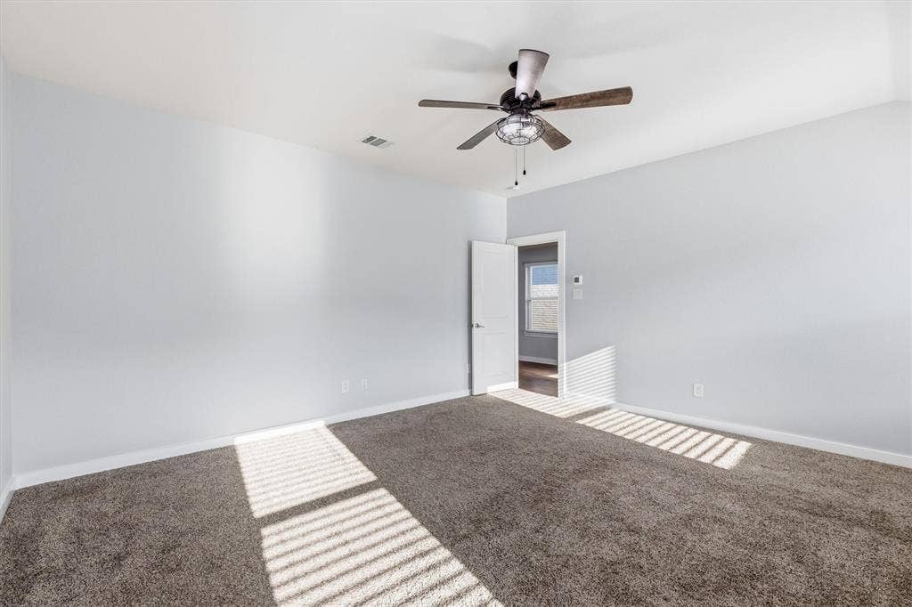 2333 Bellewood Court, Crandall, TX 75114 Neutral wall paint, ceiling fan with light fixture, gray carpet flooring, white trim, interior door
