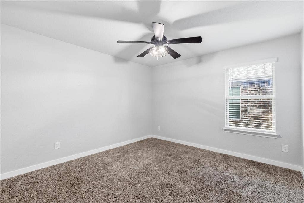 2333 Bellewood Court, Crandall, TX 75114 Neutral tone wall paint, carpeted flooring, window with blinds, and ceiling fan with lighting