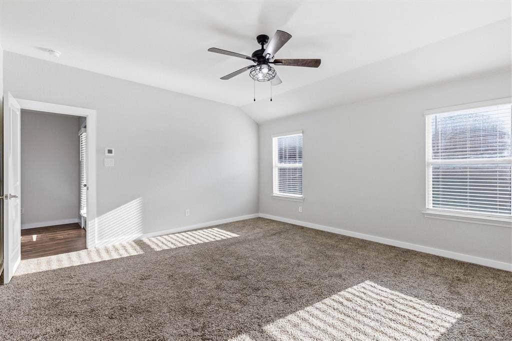 2333 Bellewood Court, Crandall, TX 75114 Vaulted ceiling with an attached ceiling fan, dual windows with blinds, and neutral carpeting