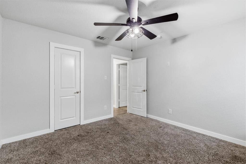 2333 Bellewood Court, Crandall, TX 75114 Carpeted flooring, contemporary ceiling fan with integrated lighting, and white paneled doors
