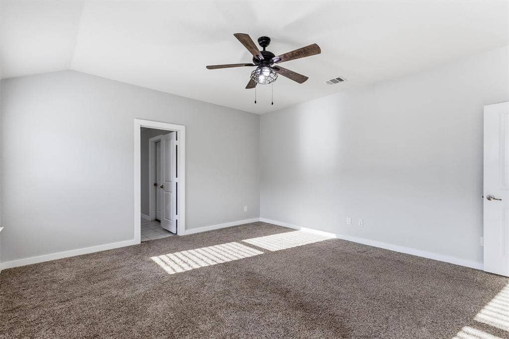 2333 Bellewood Court, Crandall, TX 75114 Vaulted ceiling with an installed ceiling fan, light gray wall paint, and gray carpet