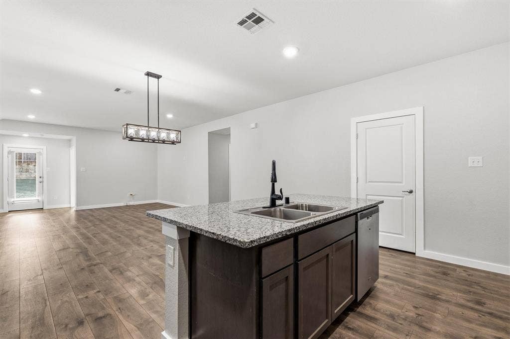2333 Bellewood Court, Crandall, TX 75114 Kitchen island featuring a double-basin sink, black faucet, and stainless steel dishwasher