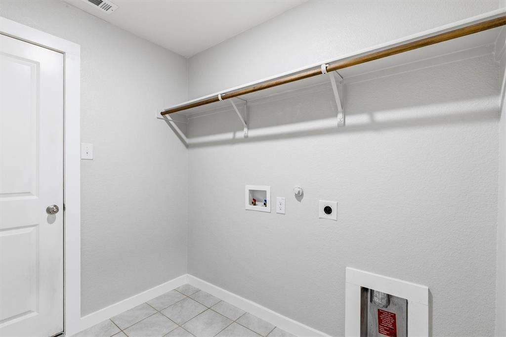 2333 Bellewood Court, Crandall, TX 75114 Utility room featuring a built-in hanging rod, wall-mounted shelving, and tile flooring