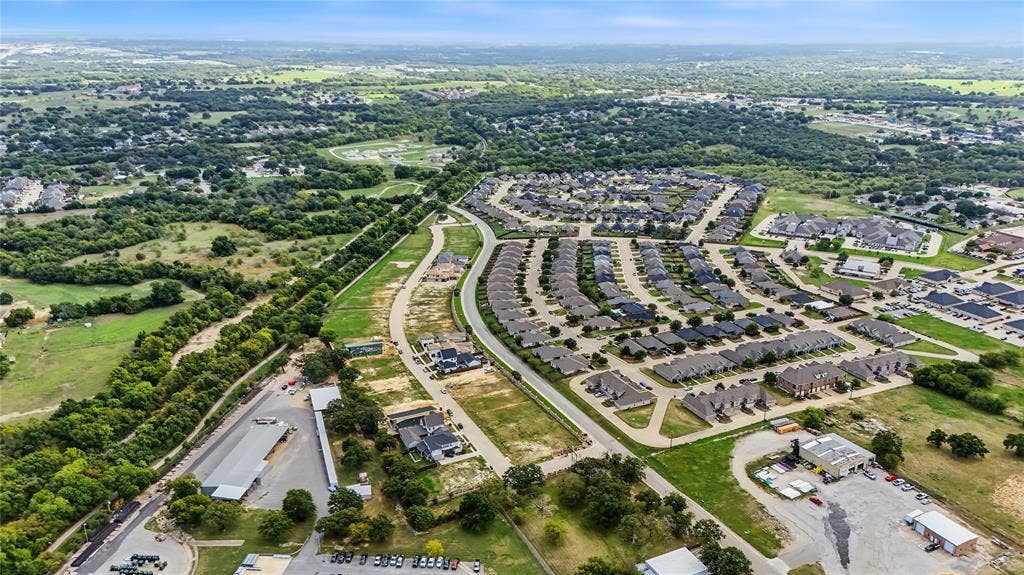 Aerial perspective of a suburban master-planned community featuring curvilinear street layouts, expansive surrounding greenbelts, and established residential density