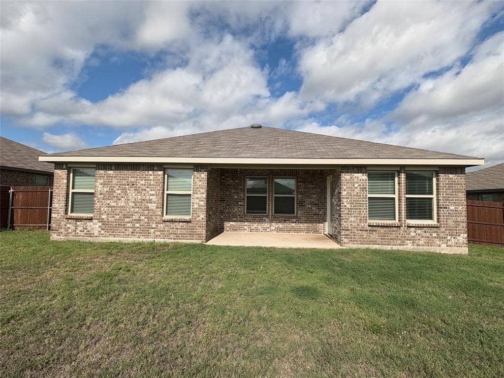 1148 Samantha Drive, Dallas, TX 75253 Rear exterior featuring a brick facade, covered patio, and multiple windows