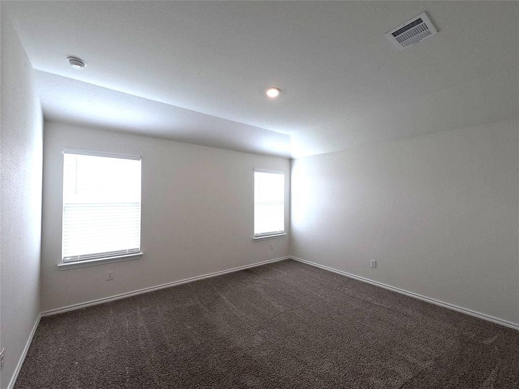 1148 Samantha Drive, Dallas, TX 75253 Spacious room with plush carpeting, multiple windows with blinds, recessed lighting, and a tray ceiling detail