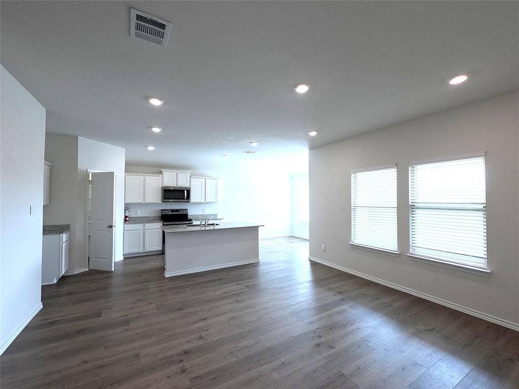 1148 Samantha Drive, Dallas, TX 75253 Open-concept living area with wood-finish flooring, recessed lighting, and multiple windows