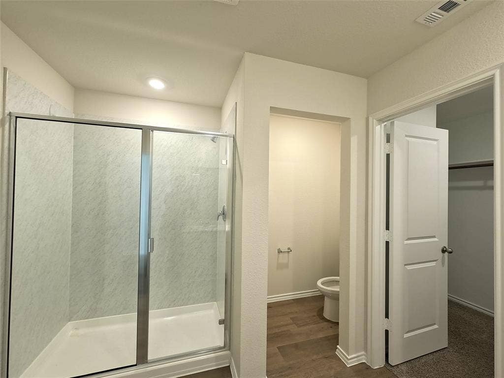 1148 Samantha Drive, Dallas, TX 75253 Glass-enclosed shower with a white base and patterned wall panels