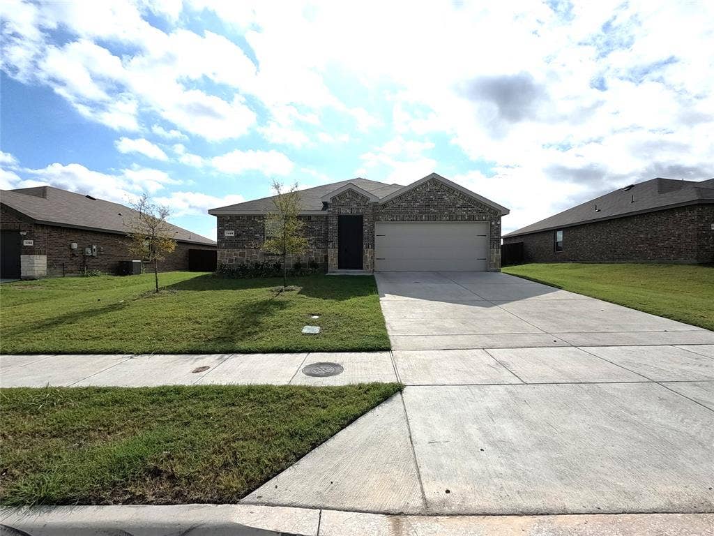1148 Samantha Drive, Dallas, TX 75253 Brick facade, attached two-car garage, concrete driveway, and a front lawn