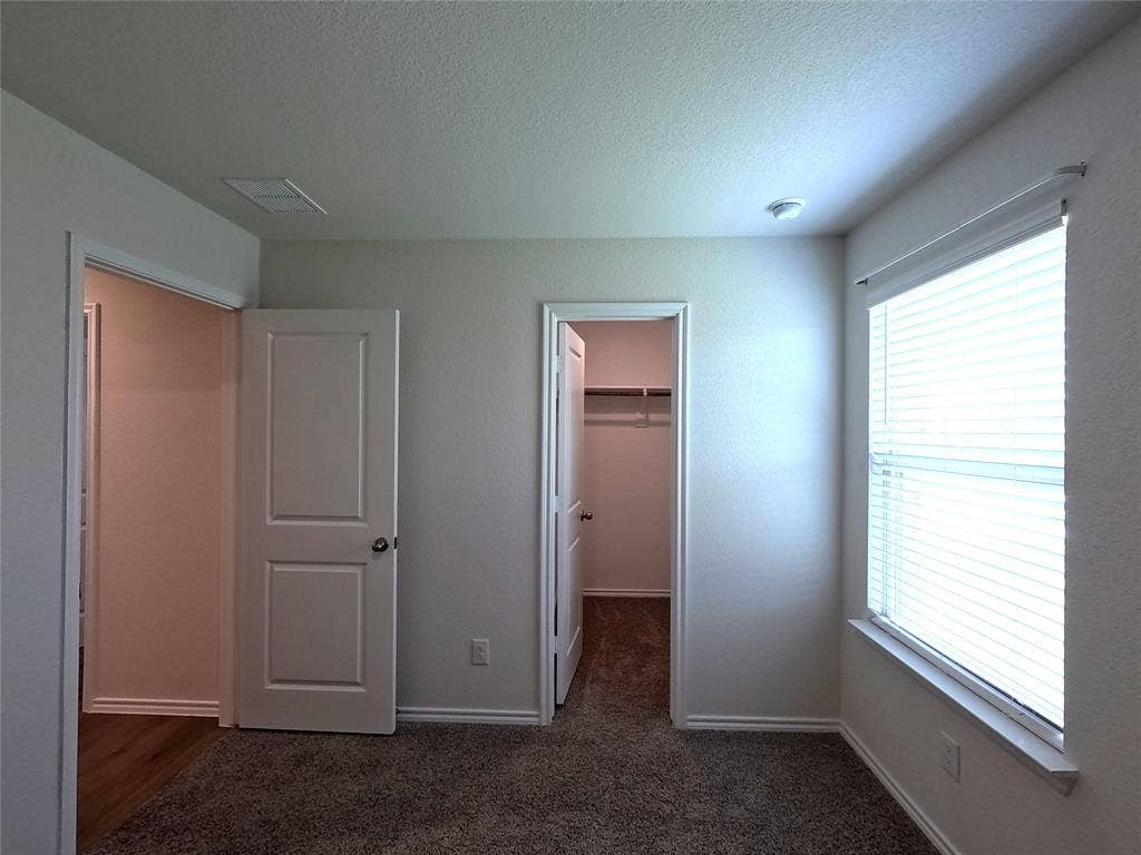 1148 Samantha Drive, Dallas, TX 75253 Plush carpeted flooring, ample natural light from a large window, white interior doors, and a built-in closet with shelving