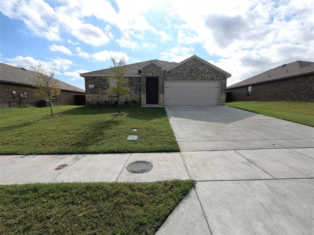 1148 Samantha Drive, Dallas, TX 75253 Brick facade with stone accents, attached two-car garage, and concrete driveway