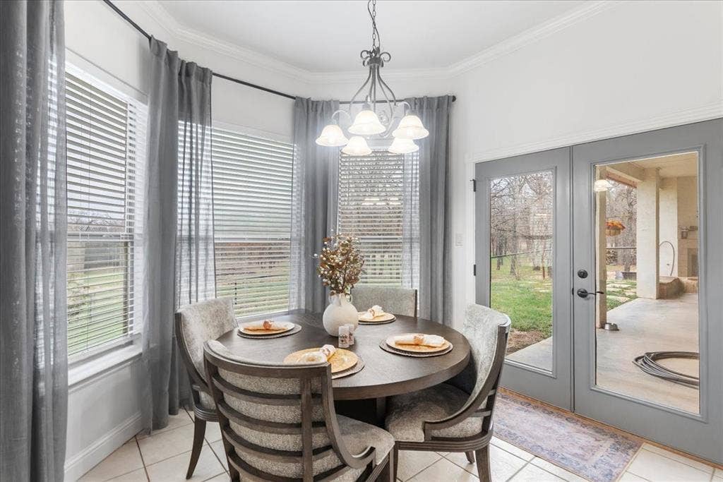 117 Redtail Court, Weatherford, TX 76088 Bay window with multi-pane windows, crown molding, tiered metal chandelier, and full-lite glass double doors leading to a covered patio