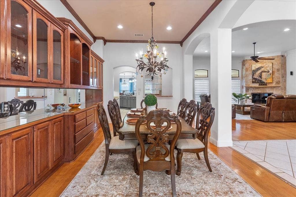 117 Redtail Court, Weatherford, TX 76088 Formal dining area featuring extensive built-in wood cabinetry, a mirrored backsplash, recessed lighting, and an ornate wrought-iron chandelier