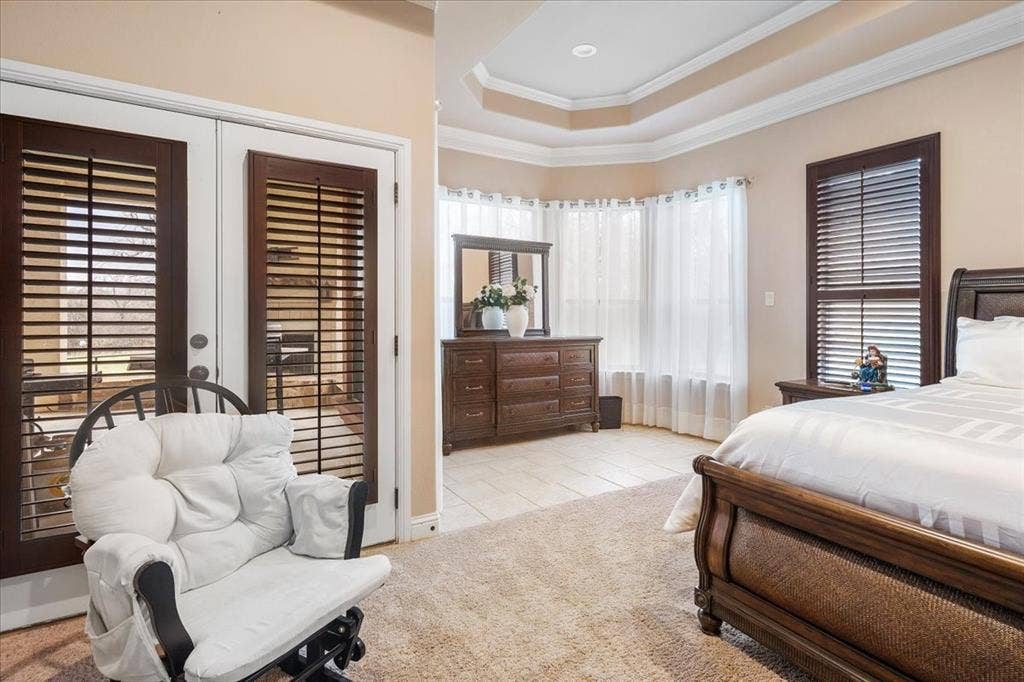 117 Redtail Court, Weatherford, TX 76088 Tray ceiling, crown molding, double French doors with plantation shutters, multiple windows, and a combination of carpet and tile flooring