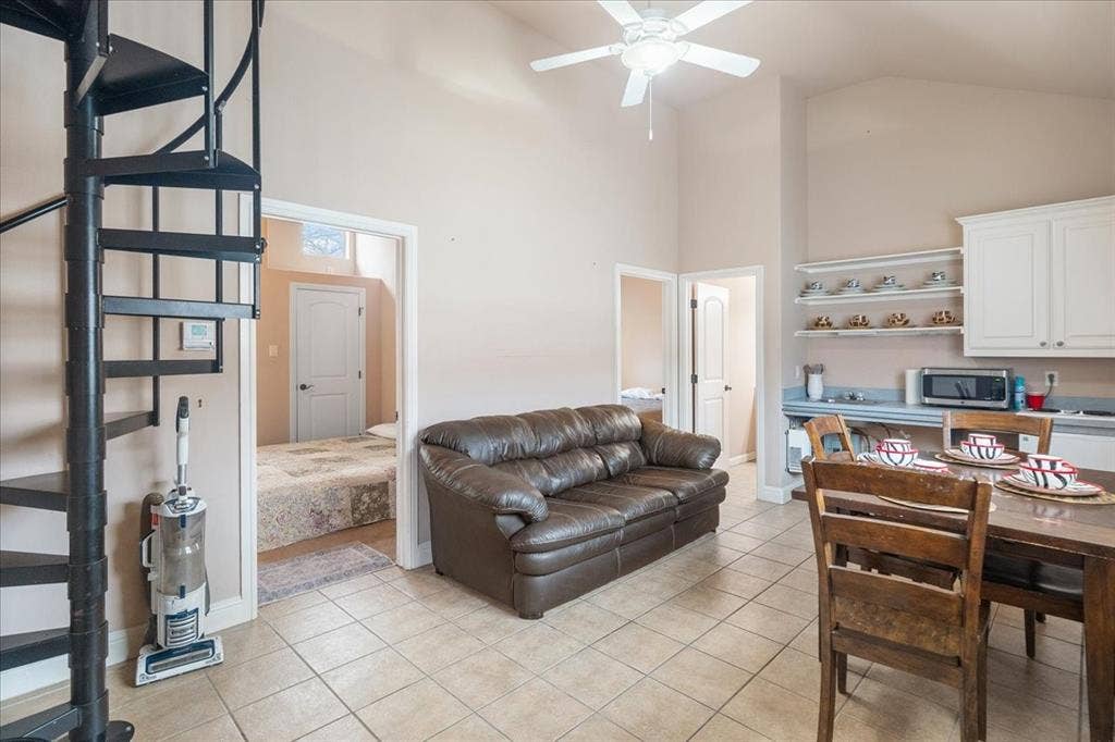 117 Redtail Court, Weatherford, TX 76088 Entrance to guest house, black metal spiral staircase, tile flooring, built-in white cabinetry, and open shelving