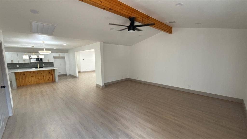 7437 Eccles Drive, Dallas, TX 75227 Vaulted ceilings featuring an exposed natural wood beam, light-tone wood-finish flooring, recessed lighting, and a modern ceiling fan