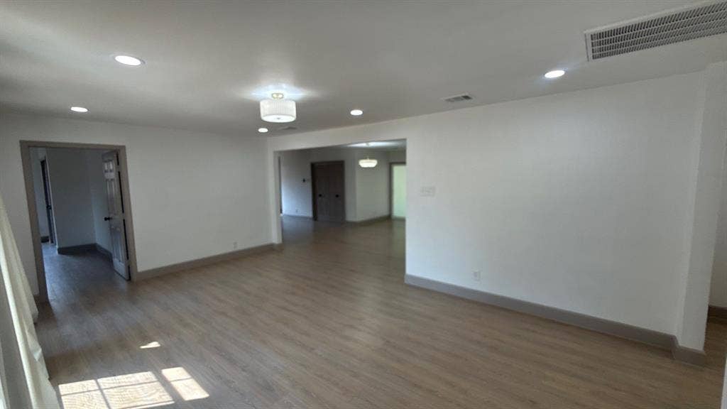 7437 Eccles Drive, Dallas, TX 75227 Neutral wall paint, wood-finish flooring, recessed lighting, and multi-light ceiling fixtures