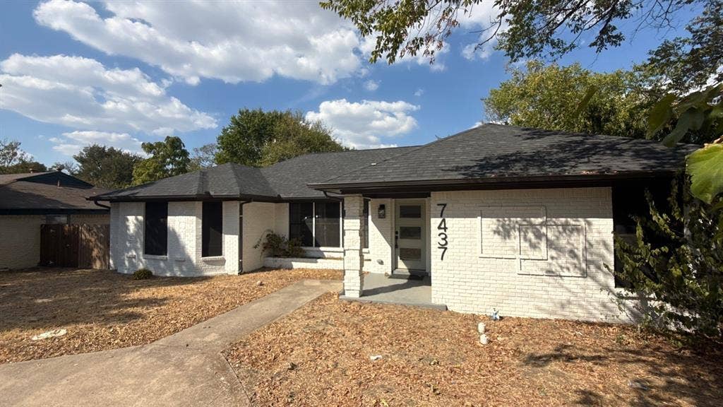 7437 Eccles Drive, Dallas, TX 75227 Single-story exterior featuring a painted brick facade, hip roof, covered porch entrance, and a modern multi-lite front door