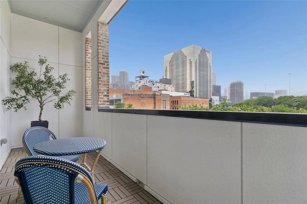 2401 Canton Street, #1002, Dallas, TX 75201 Private balcony off the main living area offers views of the Dallas skyline. Image of model home with similar layout.