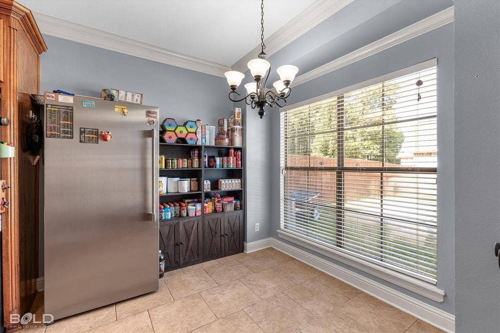 Large window featuring horizontal blinds, tile flooring, crown molding, and a five-arm metal chandelier