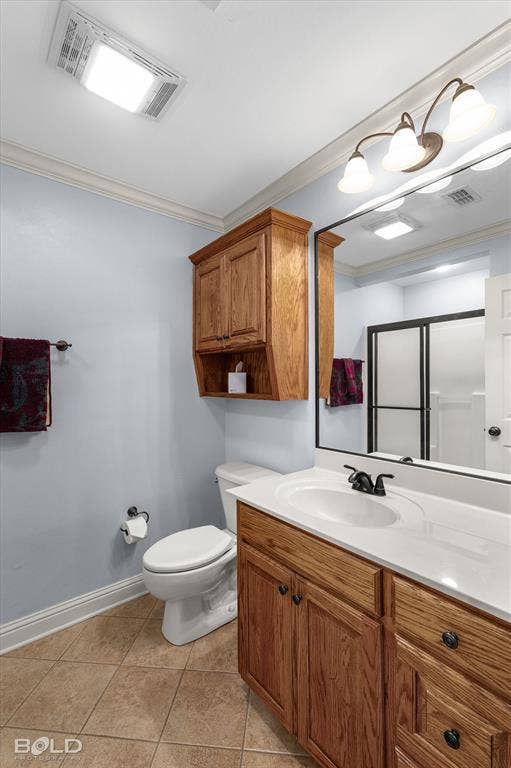Bathroom featuring a vanity with wood cabinetry, white countertop, and dark-finish hardware, paired with a matching wall-mounted cabinet, tile flooring, and a large mirror with integrated lighting