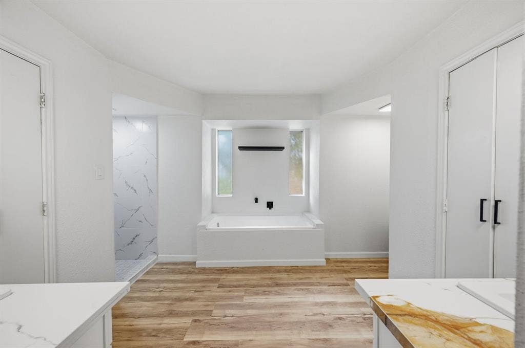 203 Evelyn Street, DeSoto, TX 75115 Gorgeous primary bathroom with deep soaking tub, walk-in shower, quartz countertops, and his & her walk-in closets!