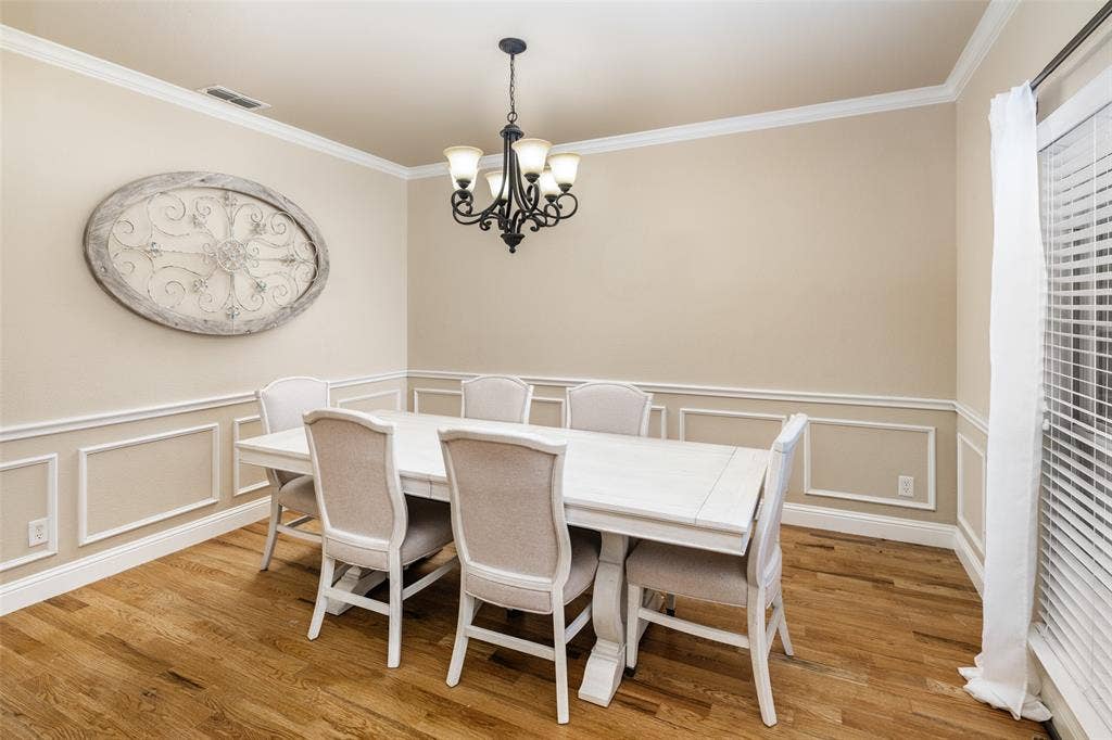 13176 Franklin Lane, Talty, TX 75126 Dining area featuring wood-finish flooring, decorative wall wainscoting, and a five-light traditional chandelier