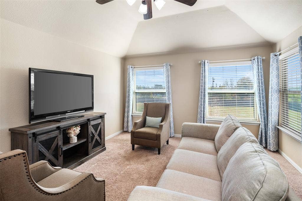 13176 Franklin Lane, Talty, TX 75126 Vaulted ceiling, ceiling fan with light fixture, and multiple windows with horizontal blinds