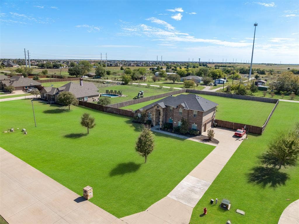 13176 Franklin Lane, Talty, TX 75126 Brick exterior residence featuring a multi-hipped roof, an expansive fenced lot, and a concrete driveway