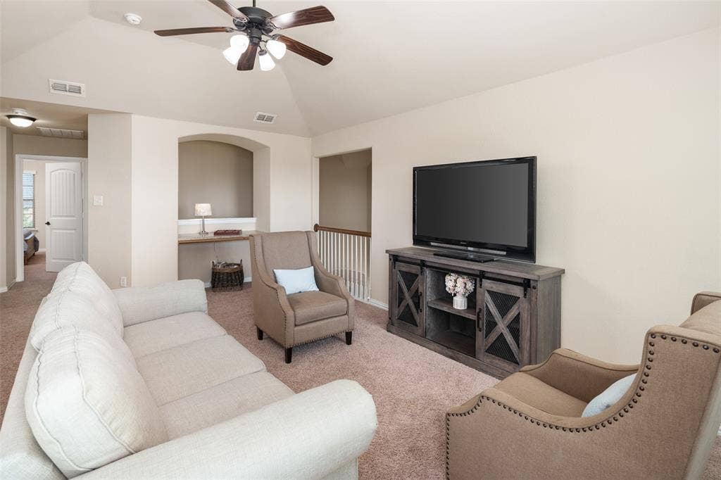 13176 Franklin Lane, Talty, TX 75126 Vaulted ceiling featuring a central lighted ceiling fan, carpeted flooring, and a built-in recessed wall niche