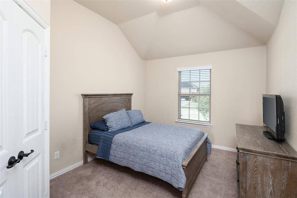 13176 Franklin Lane, Talty, TX 75126 Vaulted ceiling, wall-to-wall carpeting, window with blinds, and paneled interior door with matte black hardware
