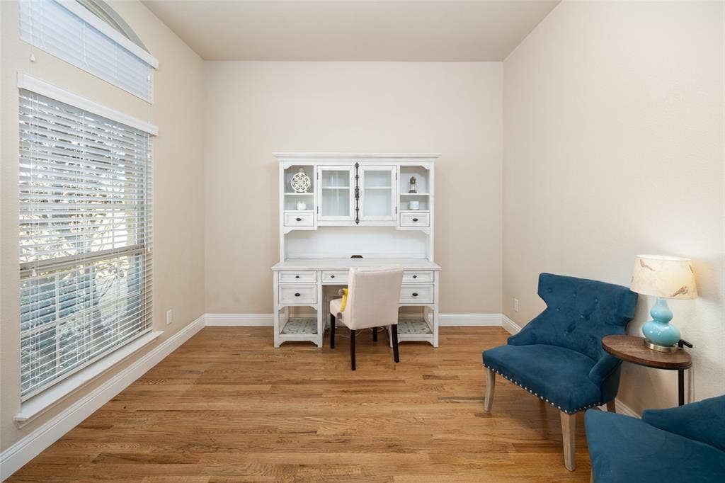 13176 Franklin Lane, Talty, TX 75126 Room featuring wood-finish flooring, high ceilings, large windows with horizontal blinds, and an arched transom window