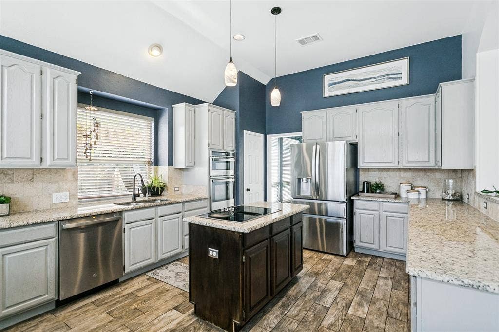 Find gray stained cabinetry, a double oven (one is a microwave + convection combination)