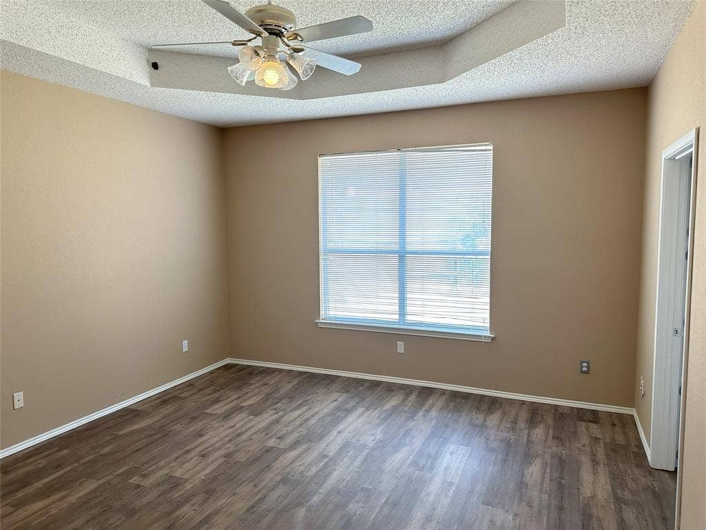 7800 Crestview Drive, Plano, TX 75024 Tray ceiling with a ceiling fan, wood-finish flooring, and a window with blinds